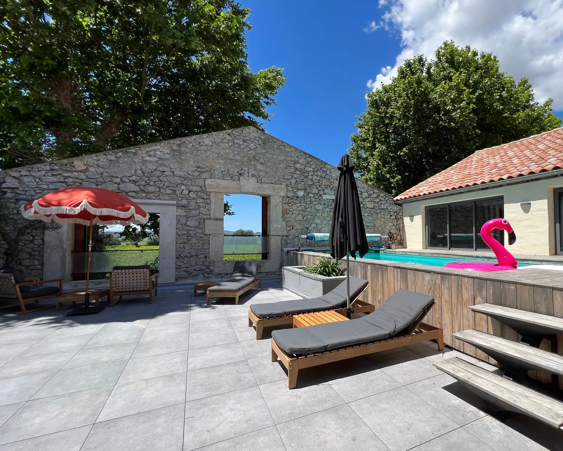 Pool-Terrasse des Penthouse mit historischer Steinmauer, Liegen und Pool
